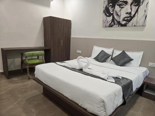 Un dormitorio con una cama grande con un cuadro en la pared. en Hotel EVA, en Gundipet