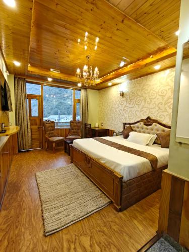 a bedroom with a large bed with a wooden ceiling at Shasha in Manāli