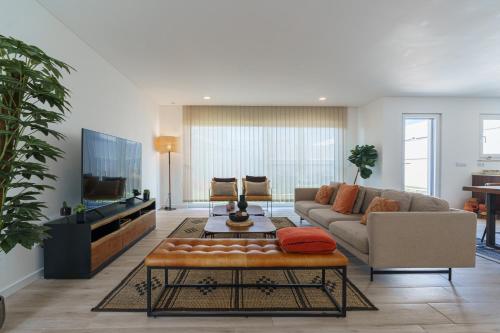 a living room with a couch and a tv at Villa Mauricio with jacuzzi and private swimming pool in Santa Barbara