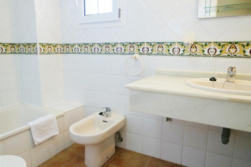a white bathroom with a sink and a toilet at Canela Park by Ĥ - Playa Isla Canela ICHP34P3 in Isla Canela