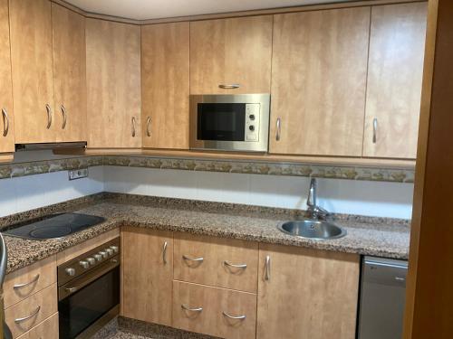 a kitchen with a sink and a microwave at Moderno adosado junto al POLIDEPORTIVO de NUCIA in Polop