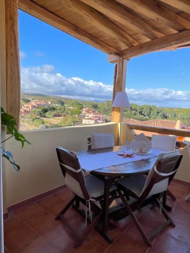 a table and chairs on a balcony with a view at Splendida vista mozzafiato Costa Rossa Sardegna in Isola Rossa