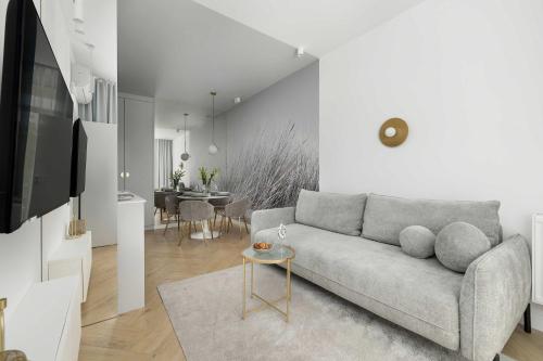 a living room with a couch and a table at Premium & Elegance Apartments with Pool by Noclegi Renters in Sianozety