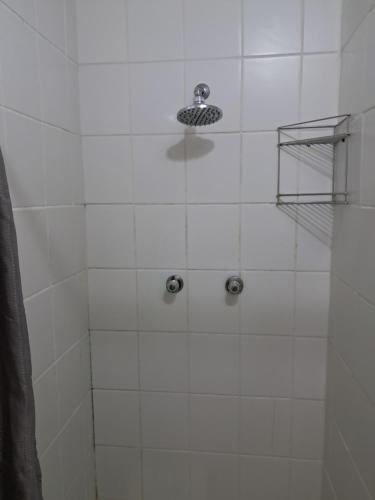 bagno con doccia e parete piastrellata bianca di Coco 's Hamlet Flatlet a Prince Alfreds Hamlet