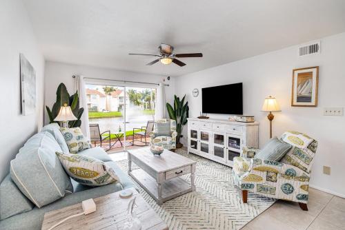 a living room with a couch and a tv at Tranquil Condo Walk to Beach in Melbourne