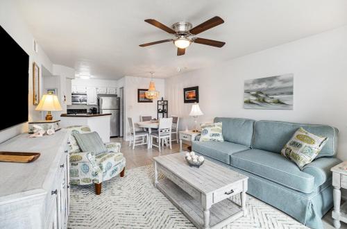 a living room with a blue couch and a table at Tranquil Condo Walk to Beach in Melbourne