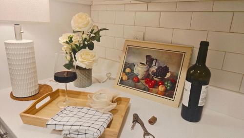 a bottle of wine and a picture of fruit on a counter at Spacious 4BR Apt, Sleeps 8, Downtown by Theaters in Providence