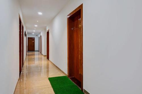 a hallway with a green rug on the floor at Super Hotel O KP Pride in Dehu