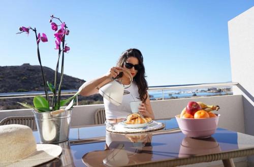 una donna che scatta una foto di un tavolo con una ciotola di frutta di Aptos Laguna Premium a Puerto de Mazarrón