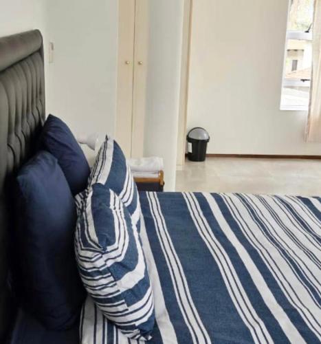 a bed with blue and white blankets and pillows at Sandton ExcluStay in Johannesburg