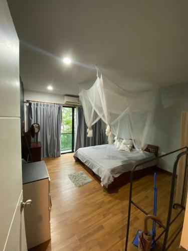 a bedroom with a bed with a mosquito net at Town House in Ban Ket Ho