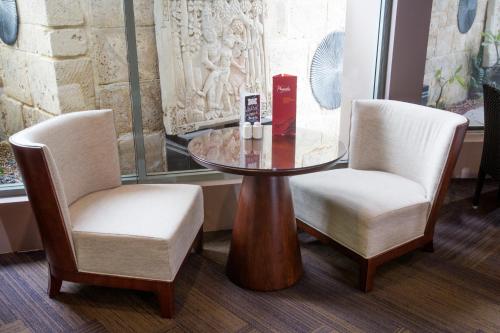 two chairs and a glass table in a room at Pagoda Resort & Spa in Perth