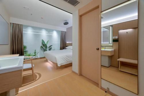 Un dormitorio con una cama, un lavabo y un espejo. en 西安万蒙酒店, en Xi'an