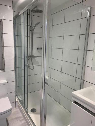 a glass shower in a bathroom with a toilet at The Albany Apartments in St. Peter Port