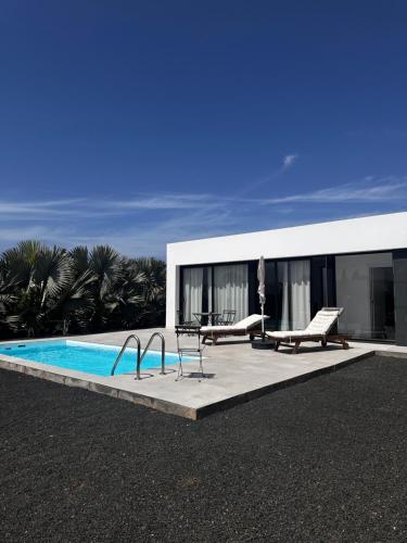 a house with a swimming pool in front of it at Duna Colorada in Lajares