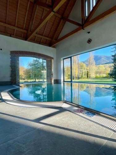 an empty swimming pool in a house with large windows at Kaštieľ Kubínyi in Dolný Kubín