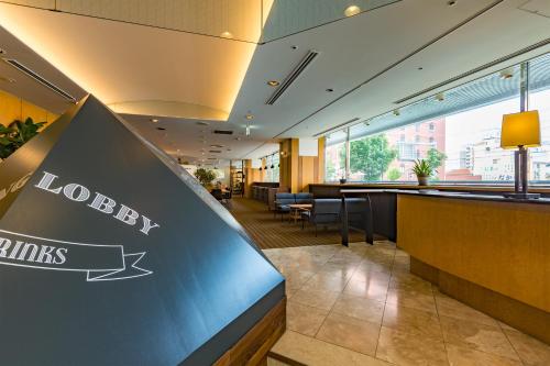 a lobby of a hotel with a sign for a happy drinks at Hotel Resol Hakodate in Hakodate