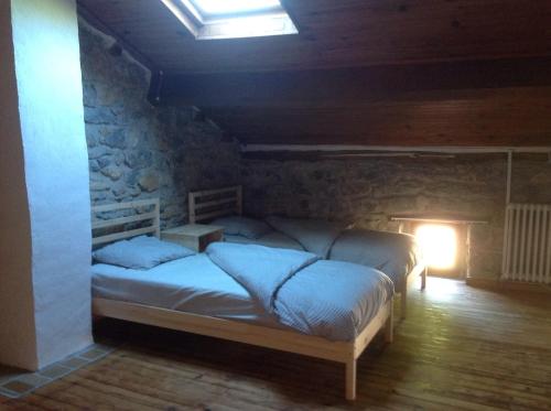 a bedroom with a bed in a stone wall at CARDABELLE maison authentique à louer in Millau
