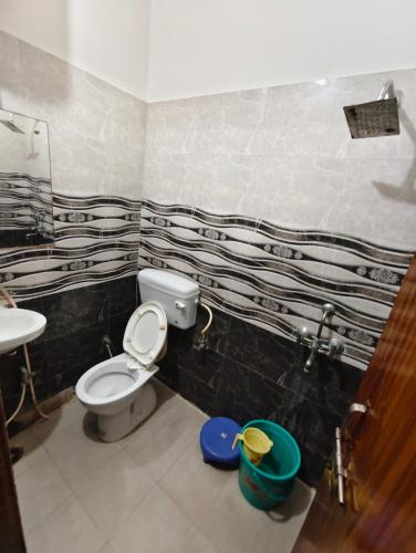 a bathroom with a toilet and a sink at Hotel Saroj Residency in Jāmb