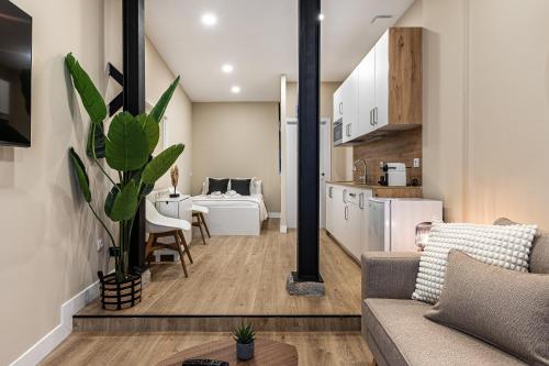 a living room with a couch and a kitchen at Waou Essence II Lavapiés - Alquiler Corta Duración in Madrid
