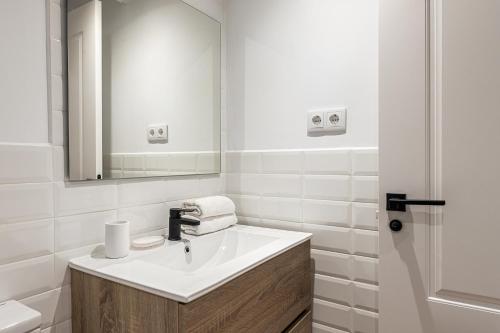 a white bathroom with a sink and a mirror at Waou Best IV Madrid Rio in Madrid
