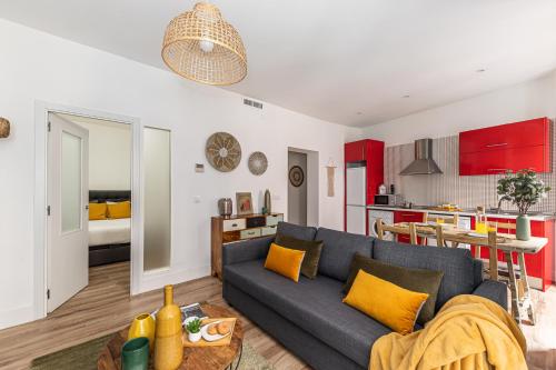 un soggiorno con un divano blu e una cucina di Waou Puerta del Sol IV - Alquiler Corta Duración a Madrid