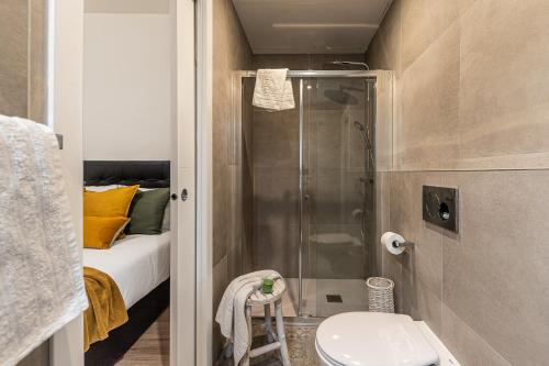 un letto e un bagno con doccia e servizi igienici. di Waou Puerta del Sol IV - Alquiler Corta Duración a Madrid