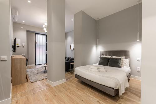 マドリードにあるWaou Essence III Tirso de Molina - Corta Duraciónの大きなベッドとリビングルームのある寝室