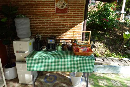 een picknicktafel met een groen-wit geblokt tafelkleed bij La Atta in Phetchaburi