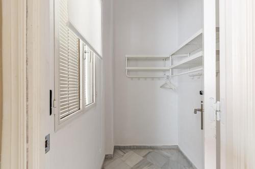 un corridoio bianco con finestra e porta di Waou Sevilla Centro II a Siviglia