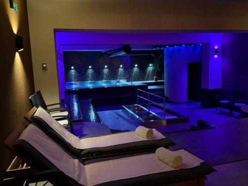 Zimmer mit einem Pool mit violetter Beleuchtung in der Unterkunft LH Parkhotel Hluboka Nad Vltavou Congress & Wellness in Hluboká nad Vltavou