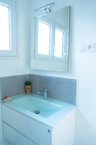 a bathroom with a white sink and a mirror at EMY guest HOUSE in Kofa