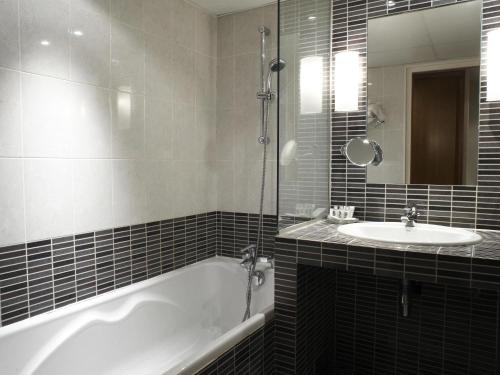 a bathroom with a tub and a sink at Mercure Marseille Centre Bompard La Corniche in Marseille