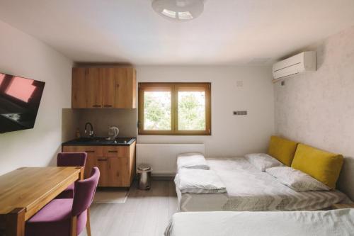 a room with two beds and a table and a kitchen at Apartmani Vesto in Banja Luka