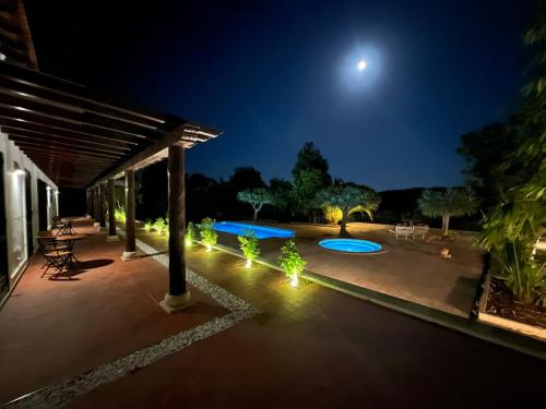 a patio at night with the moon in the sky at Colonial Farmhouse with Cottage - Lugar Minas da Caveira in Grândola
