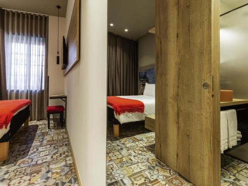 a hotel room with two beds and a mirror at ibis Styles Chaves in Chaves