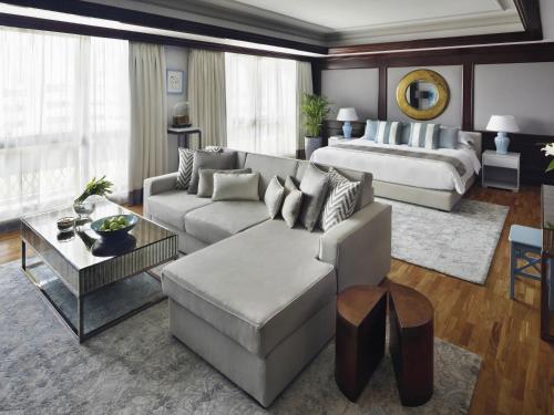 a living room with a couch and a bed at Mövenpick Hotel & Apartments Bur Dubai in Dubai
