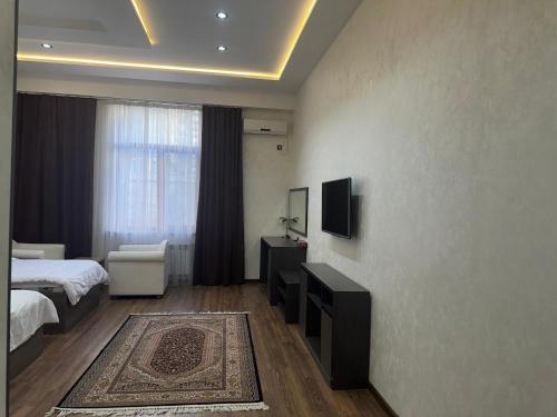 a bedroom with a bed and a television on a wall at Baland Vatan Hotel in Dushanbe