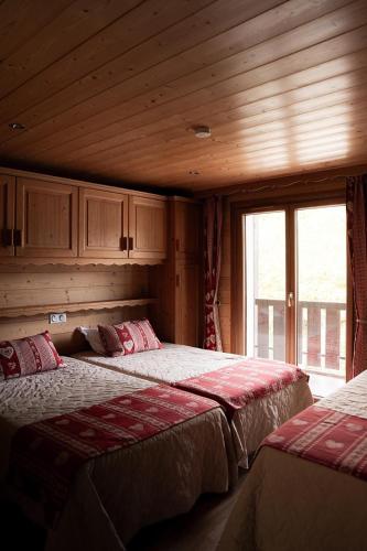 a bedroom with two beds and a window at Chardonneret 3 in La Clusaz