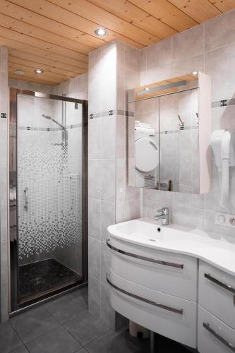 a bathroom with a shower and a white sink at Chardonneret 3 in La Clusaz