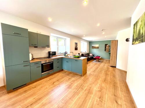 a kitchen with blue cabinets and a living room at Ferienwohnungen Im Dorfe in Soltau