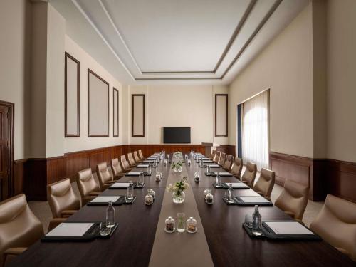 a large conference room with a long table and chairs at Mövenpick Hotel Cairo - Media City in 6th Of October