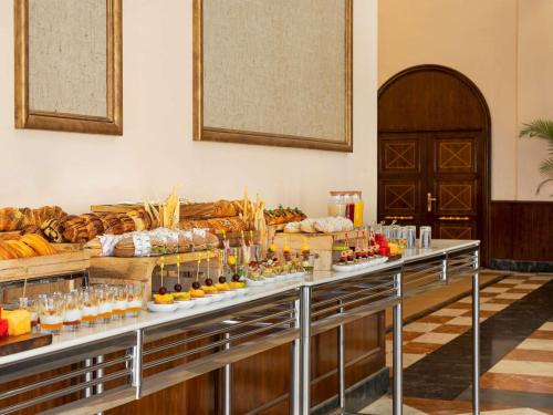 a buffet line with food and drinks on display at Mövenpick Hotel Cairo - Media City in 6th Of October