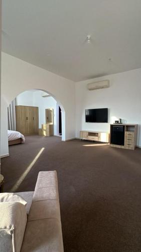 a large living room with a couch and a flat screen tv at Khalifa A Home Stay Suite Room in Abu Dhabi