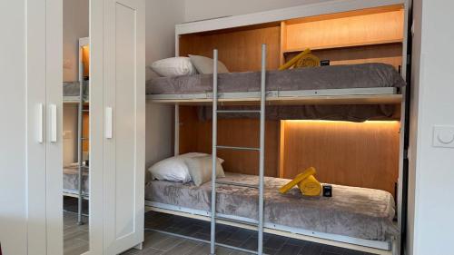 two bunk beds in a room with a mirror at LE COCOON - Proche Centre - Climatisation - Wifi in Menton