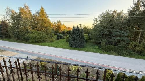 an empty road with a fence and trees at Agroturystyka u Witka in Brynica Mokra