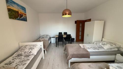 a room with two beds and a dining room with a table at Agroturystyka u Witka in Brynica Mokra