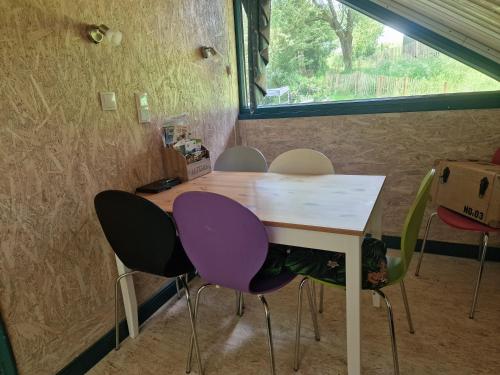 a table and chairs in a room with a window at Bootshaus Froschkönig übernachten über dem Weiher in Hundsdorf