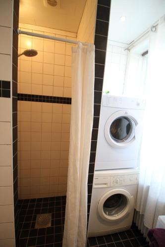 a washer and dryer in a small bathroom at Gästlägenhet in Sövde
