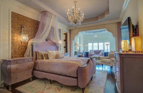 ein Schlafzimmer mit einem großen Bett und einem Kronleuchter in der Unterkunft Elegant Caribbean Villa With Grand Design in Love